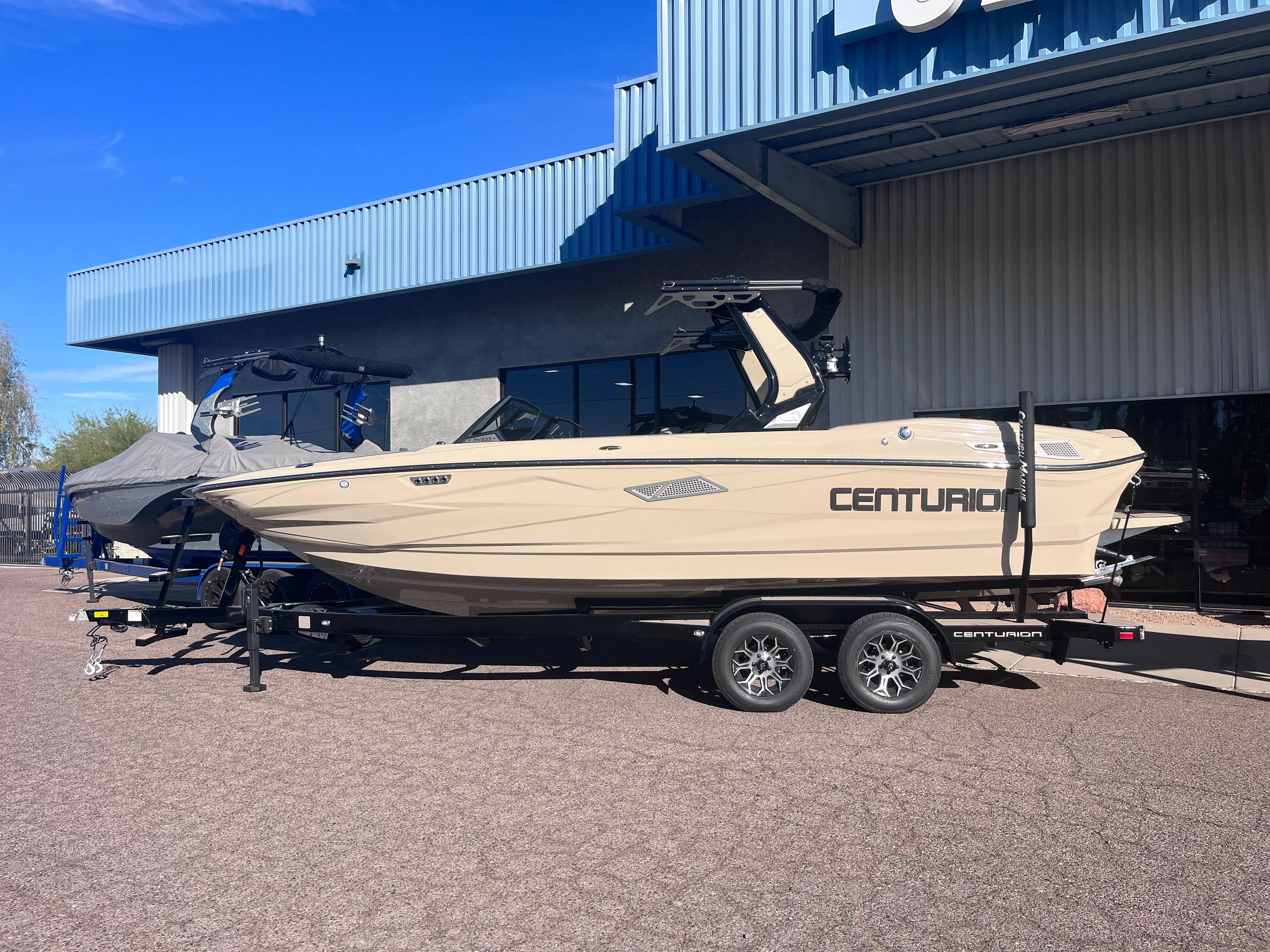 Centurion Nv233 2025 Centurion Nv233 boat on trailer outside a building under clear blue sky.