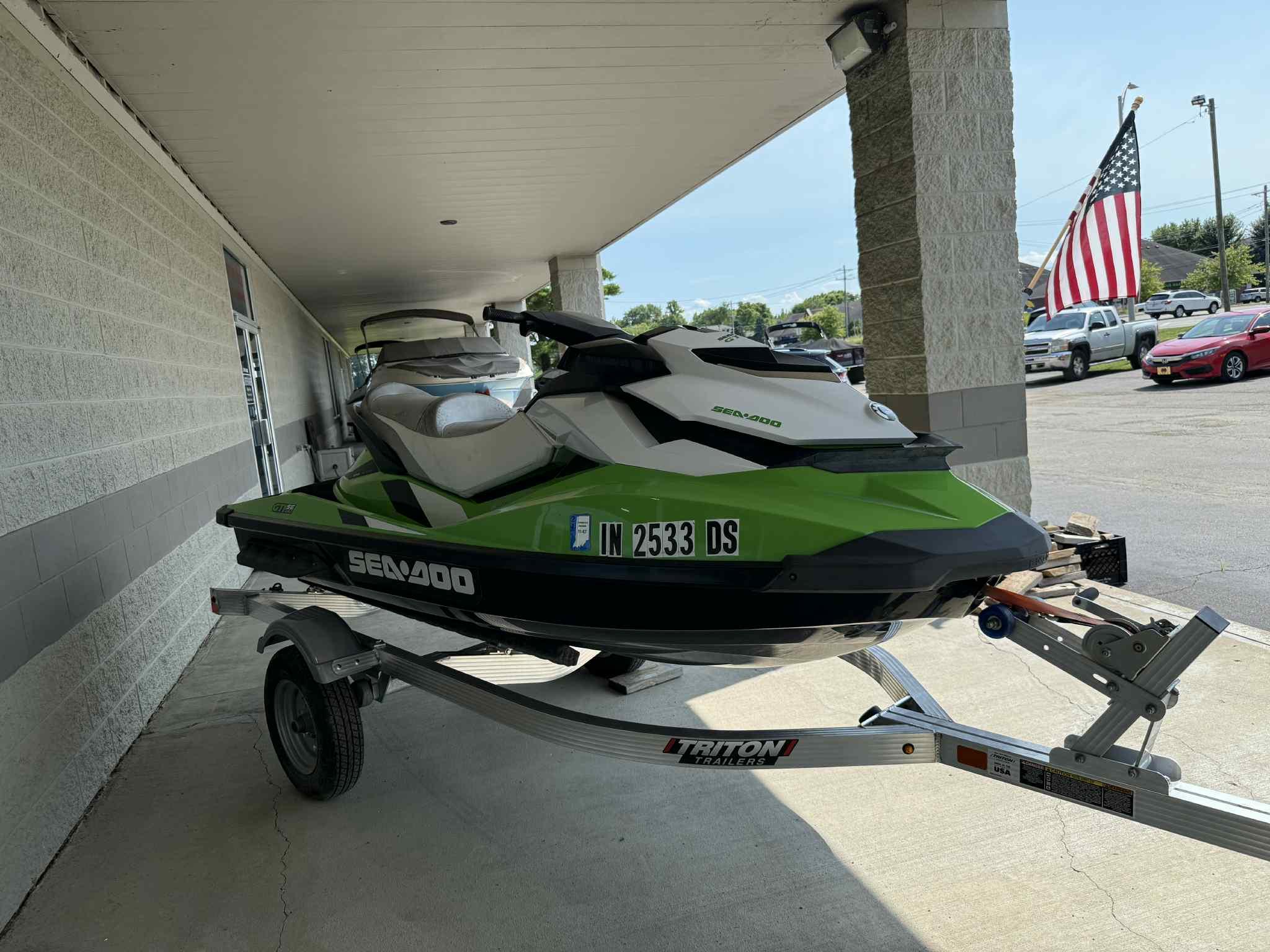 Sea-Doo GTI SE 130 2013 Sea-Doo GTI SE 130 jet ski on trailer, parked under a canopy.