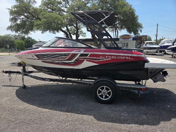 Regal 1900 ES Bowrider 2017 Regal 1900 ES Bowrider boat on trailer, red and black design, parked outdoors.