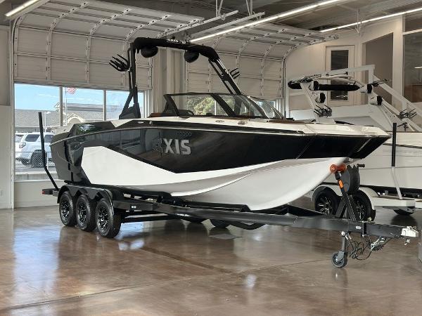 Axis A245 2025 Axis A245 boat on trailer in showroom, featuring sleek black and white design.