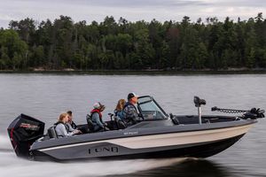 Lund 185 Impact GL Manufacturer Provided Image: 2025 Lund 185 Impact GL boat cruising on a lake with passengers, forested shoreline in background.