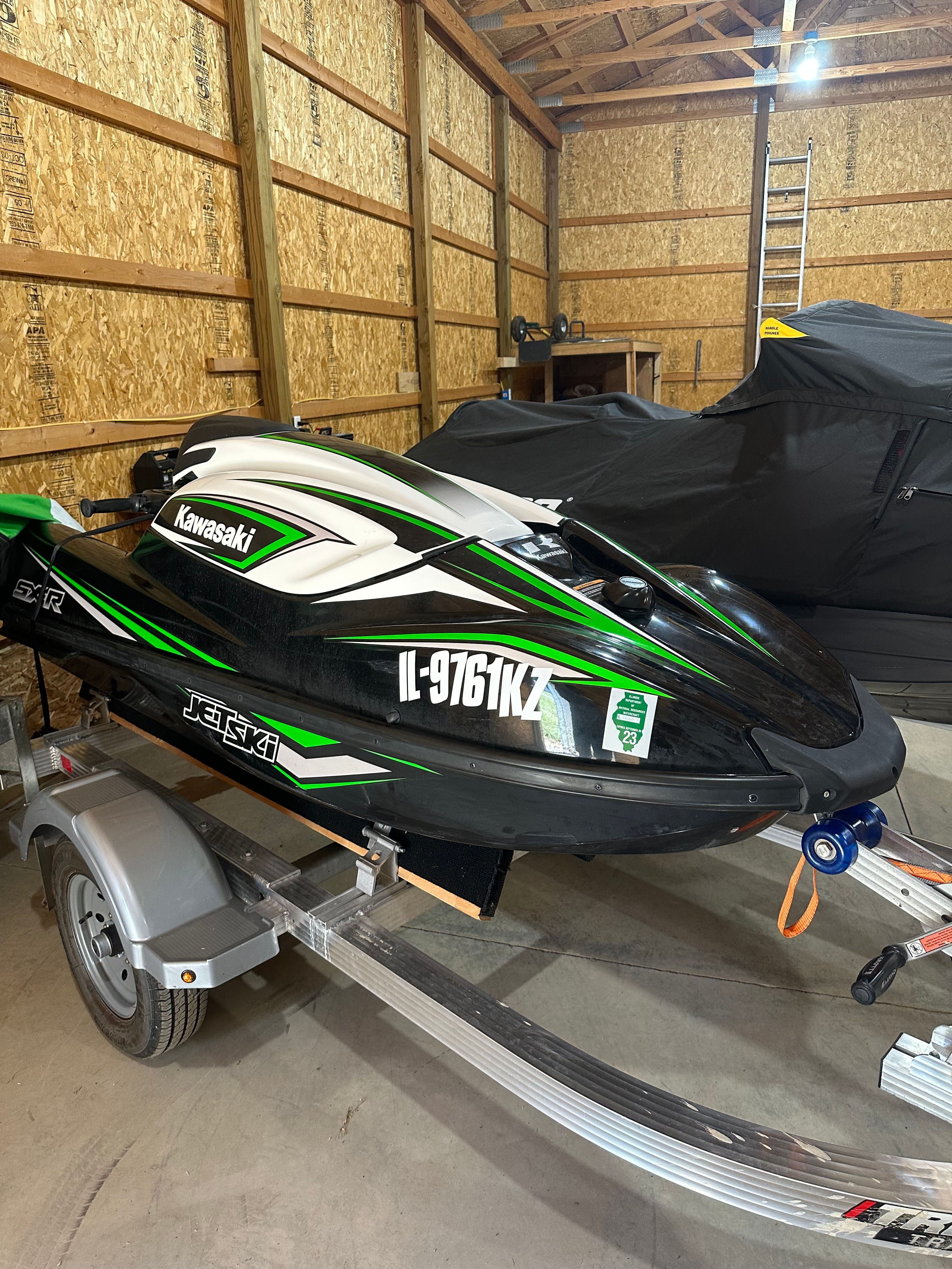 Kawasaki SXR 2018 Kawasaki SXR jet ski on trailer in wooden garage.