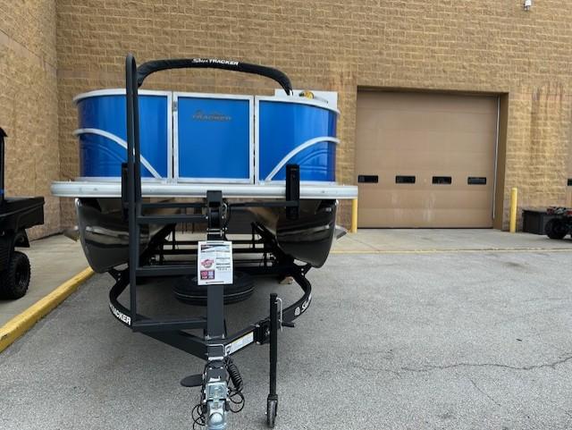 Sun Tracker Party Barge 16 DLX 2026 Sun Tracker Party Barge 16 DLX pontoon boat on trailer, parked near a building.