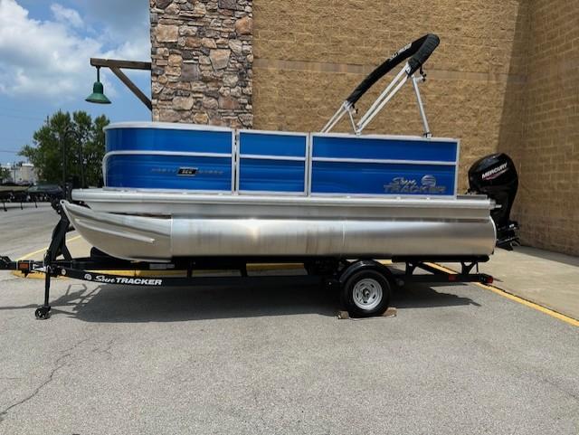 Sun Tracker Party Barge 16 DLX 2026 Sun Tracker Party Barge 16 DLX pontoon boat on trailer, parked outdoors.