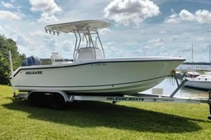 Release 208RX 2017 Release 208RX boat on trailer, parked on grass near water under a cloudy sky.