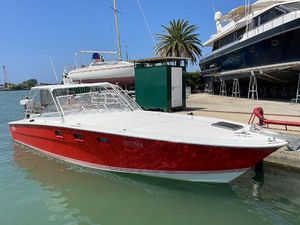 Magnum 35 ht 1974 Magnum 35 HT boat with red hull docked in a sunny marina.