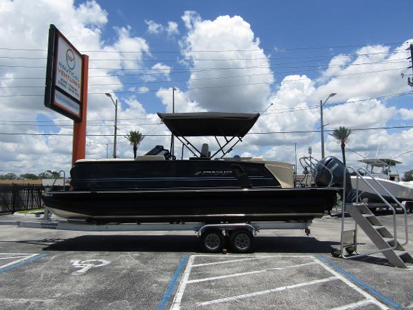 Starcraft RX 23 Q DC 2024 Starcraft RX 23 Q DC pontoon boat on a trailer in a parking lot.