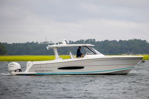 Regal 38 SAV 2022 Regal 38 SAV boat cruising on a scenic waterway with lush greenery.