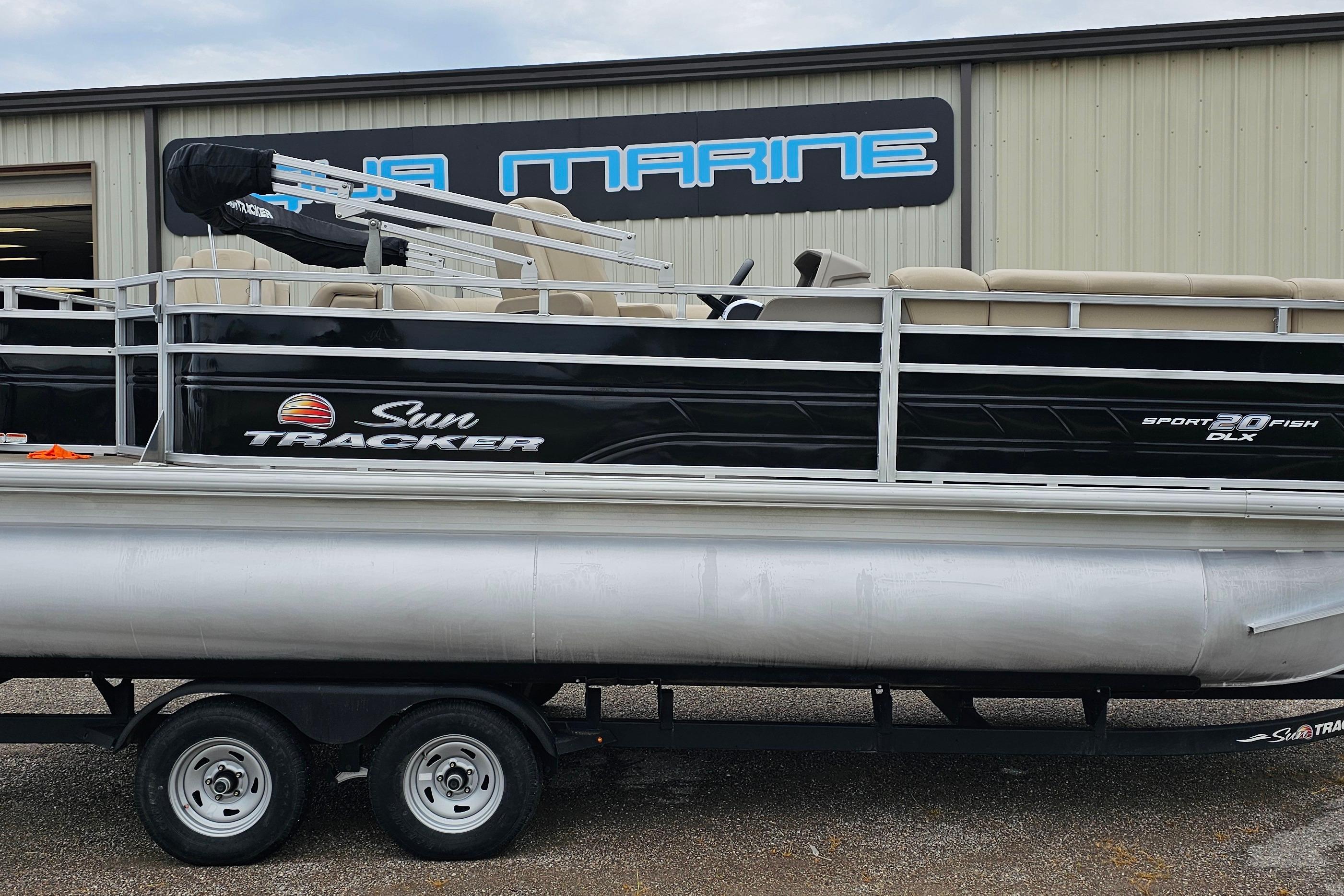 Sun Tracker SportFish 20 DLX 2024 Sun Tracker SportFish 20 DLX pontoon boat on trailer outside marine shop.