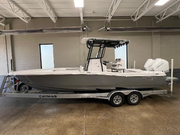 Caymas 281 HB 2024 Caymas 281 Hybrid boat on a trailer in a showroom.