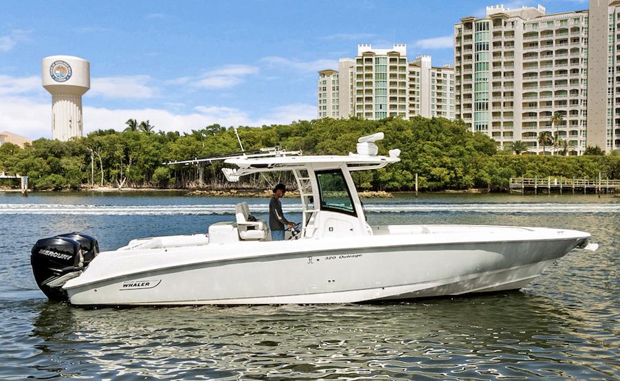 Boston Whaler 320 Outrage 2014 Boston Whaler 320 Outrage boat on water, with cityscape and greenery in background.