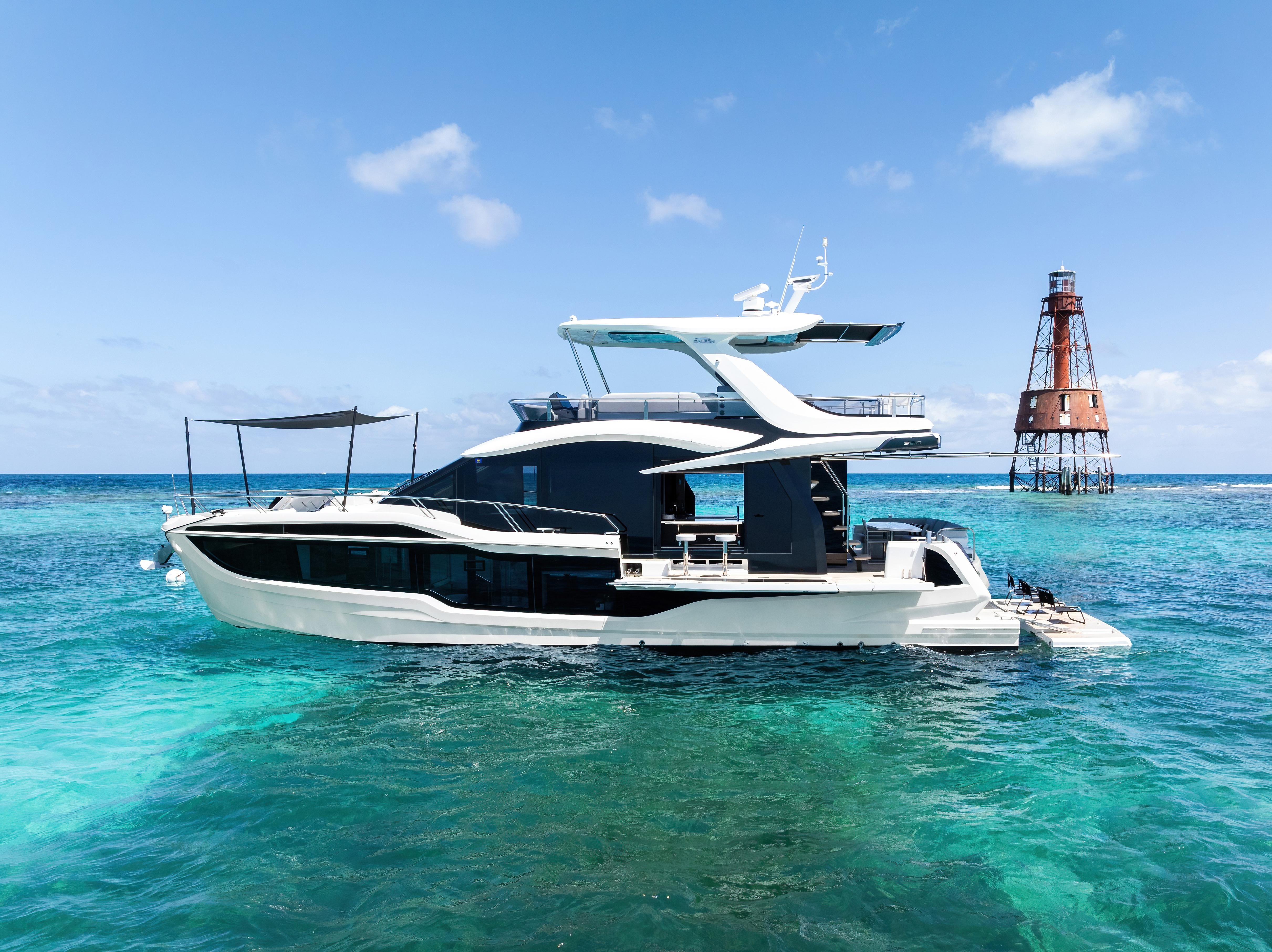Galeon 560 Fly 2024 Galeon 560 Fly yacht on clear blue ocean near a lighthouse.
