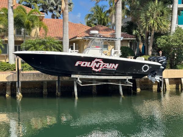Fountain 34 Center Console 2008 Fountain 34 Center Console boat docked by palm trees and waterfront homes.