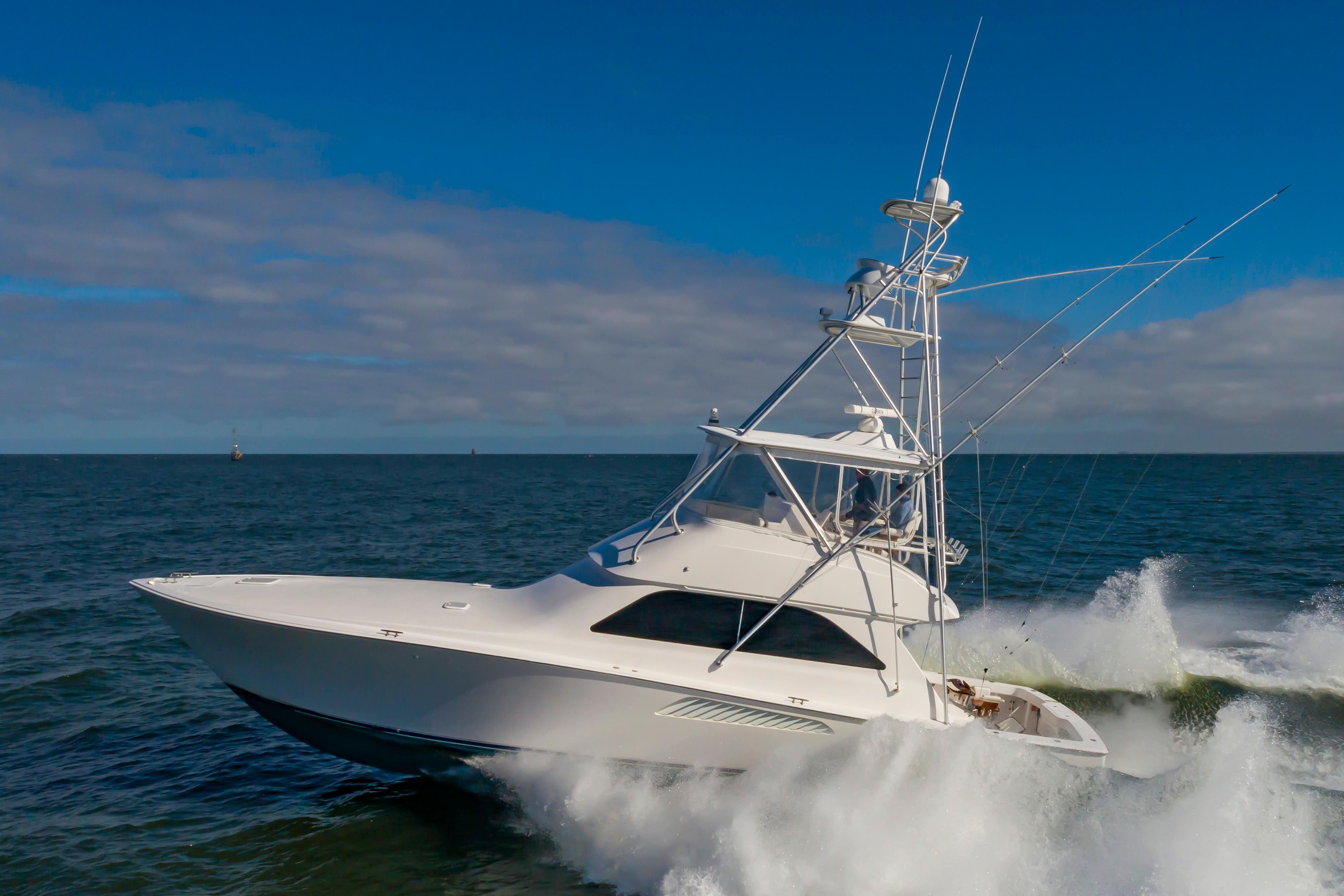 Viking Convertible 2005 Viking Convertible yacht cruising on open sea with blue sky background.