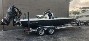 ShearWater X22 HYBRID 2025 ShearWater X22HP boat on trailer with outboard motor, parked outdoors.