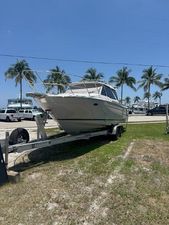 Cutwater C-248 Coupe 2025 Cutwater C-248 Coupe boat on trailer, parked outdoors with palm trees in the background.
