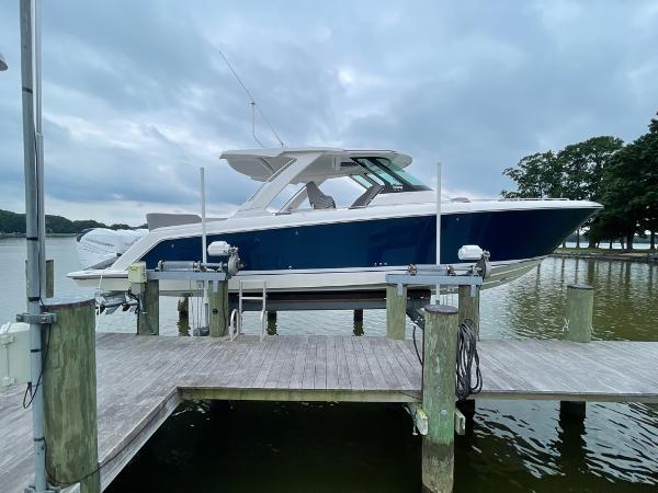 Tiara Yachts 38 LS 2023 Tiara Sport 38 LS boat docked on a lift by the water.