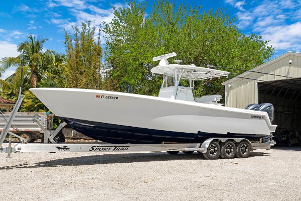 Contender 35 ST 2024 Contender 35 ST boat on trailer, parked outdoors near trees and a building.