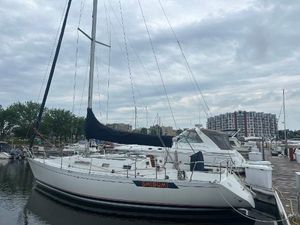 Beneteau First 375 1986 Beneteau First 375 sailboat docked at marina under cloudy sky.