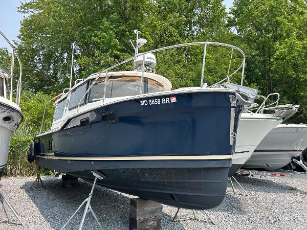 Ranger Tugs R-27 2021 Ranger Tugs R-27 boat on stands, blue hull, parked outdoors.