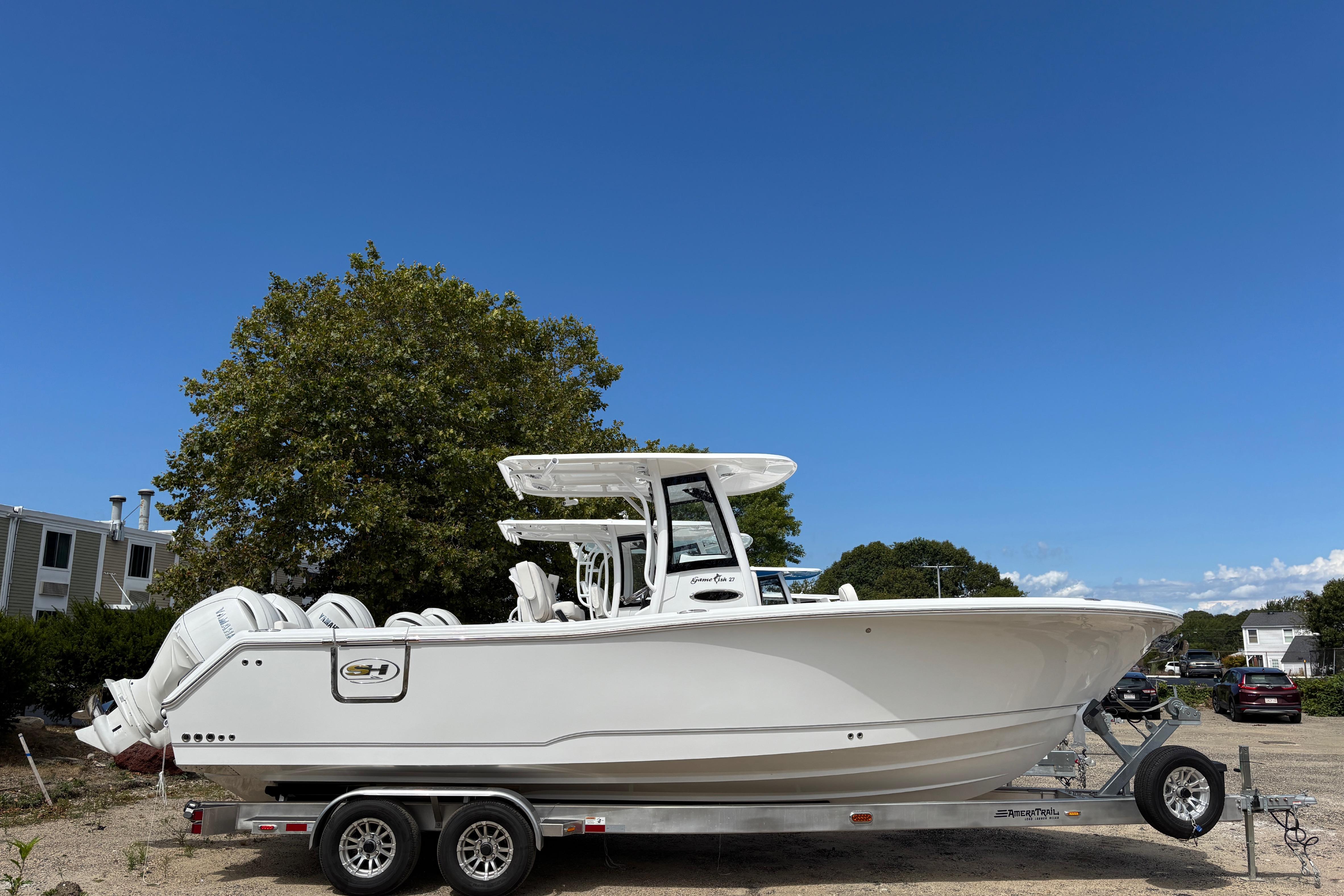 Sea Hunt Gamefish 27 2026 Sea Hunt Gamefish 27 boat on trailer under clear blue sky.
