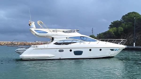 Azimut 47 Fly 2007 Azimut 47 Fly yacht on water, cloudy sky, and lush greenery in the background.