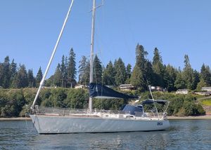 J Boats 44 1990 J Boats 44 sailboat on calm water with forested shoreline background.