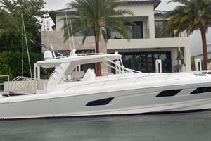 Intrepid 477 Evolution 2022 Intrepid 477 Evolution yacht docked near a modern waterfront home.