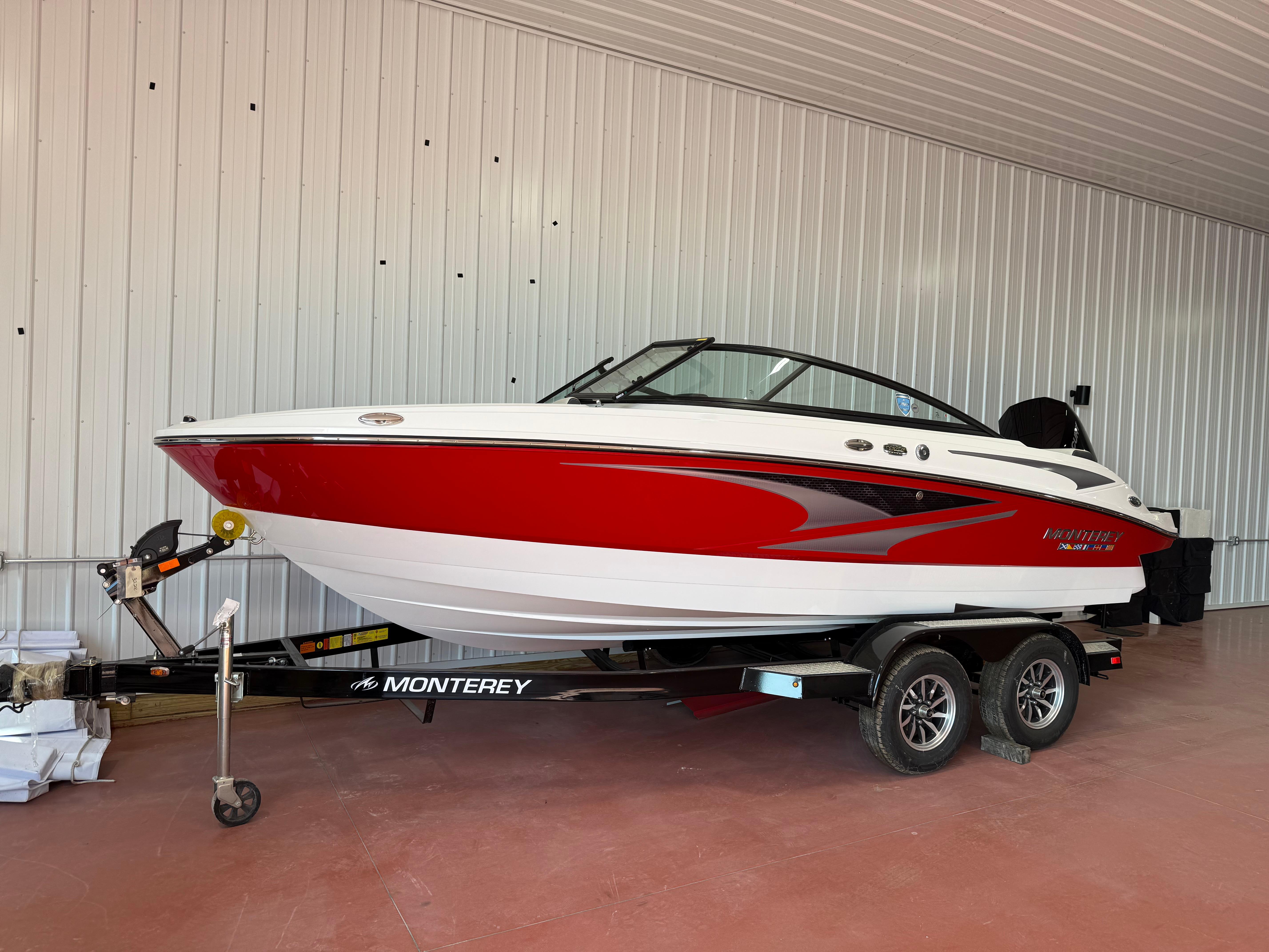 Monterey M205 2024 Monterey M205 boat in red and white on a trailer in a garage.
