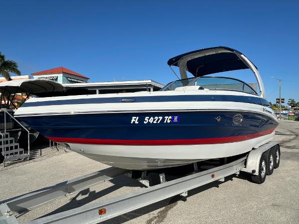 Crownline 260 XSS 2022 Crownline 260 XSS boat on trailer, blue and white design, sunny day.