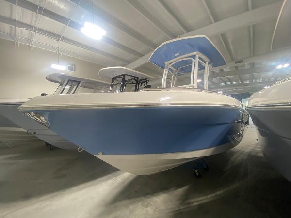 Robalo R222 2024 Robalo R222 boat in showroom, blue hull, white interior, under indoor lighting.