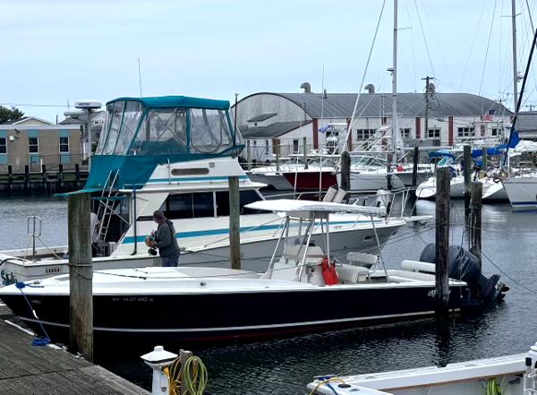 Intrepid 30 CONSOLE CUDDY 1990 Intrepid 30 Console Cuddy boat docked in a marina with other vessels.