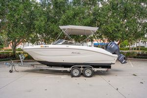 Hurricane SunDeck 217 OB 2025 Hurricane SunDeck 217 OB boat on trailer, parked outdoors with trees in background.