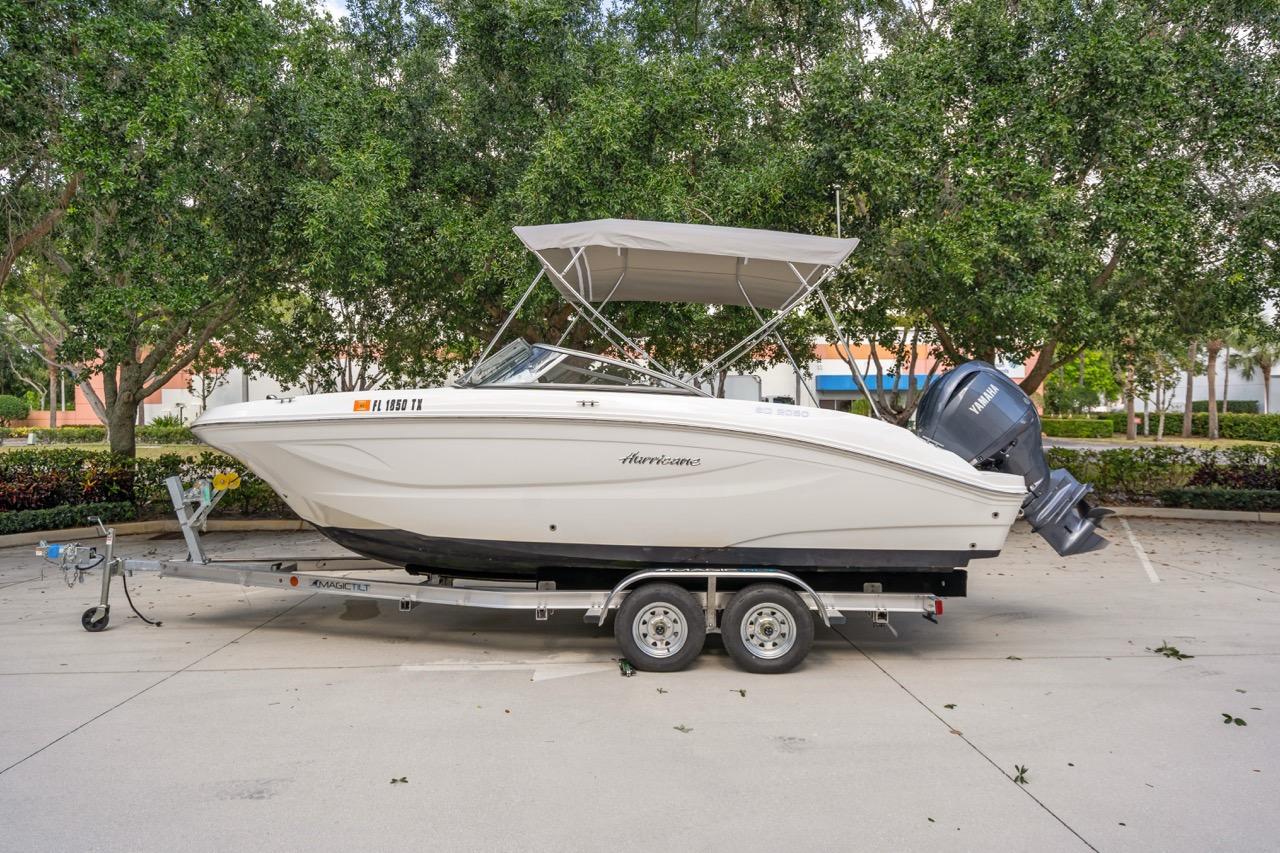 Hurricane SunDeck 217 OB 2025 Hurricane SunDeck 217 OB boat on trailer, parked outdoors with trees in background.
