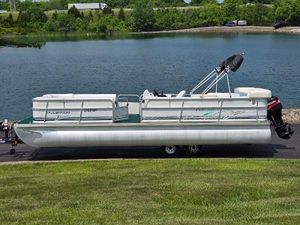 Odyssey Pontoons 2505 Millennium 2000 Odyssey Pontoons 2505 Millennium on trailer by a lake.