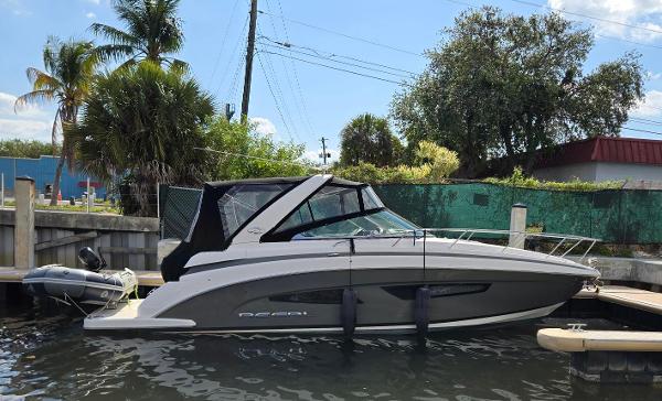 Regal 32 Express 2017 Regal 32 Express boat docked near tropical trees and buildings.
