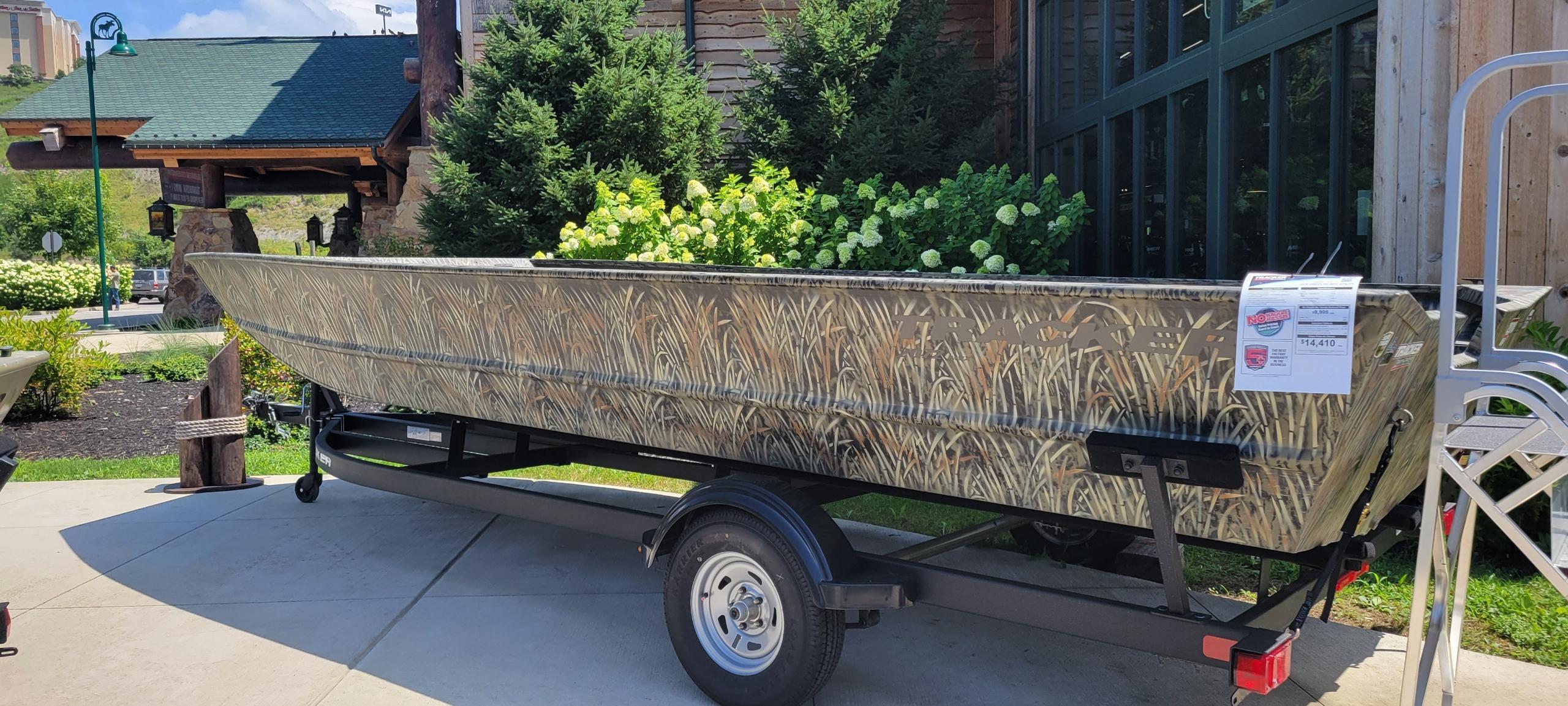 Tracker GRIZZLY 2072 Utility 2025 Tracker GRIZZLY 2072 Utility boat with camouflage design on a trailer outdoors.