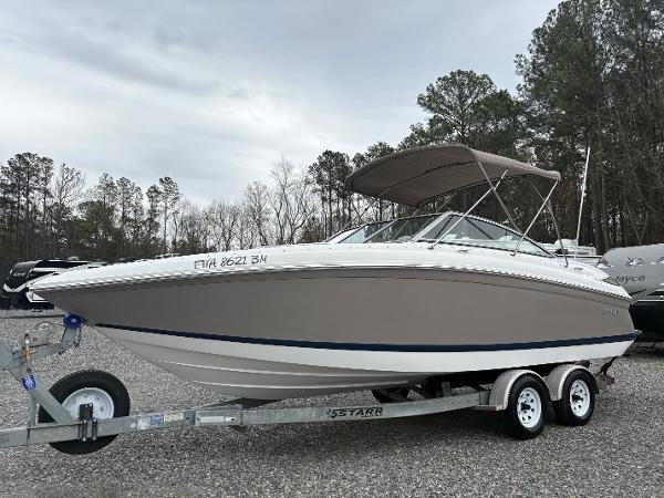 Cobalt 232 Bowrider 2007 Cobalt 232 Bowrider boat on trailer, parked outdoors with trees in background.