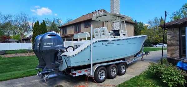 Cobia 277 Center Console 2017 Cobia 277 Center Console boat on trailer, parked in residential driveway.