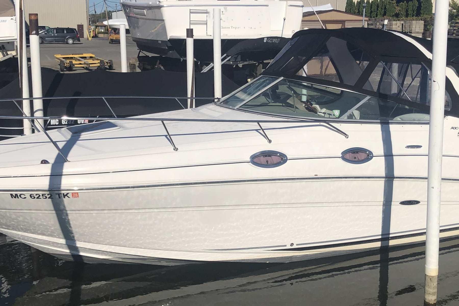 Sea Ray 280 Sundancer 2005 Sea Ray 280 Sundancer boat docked at marina, side view.