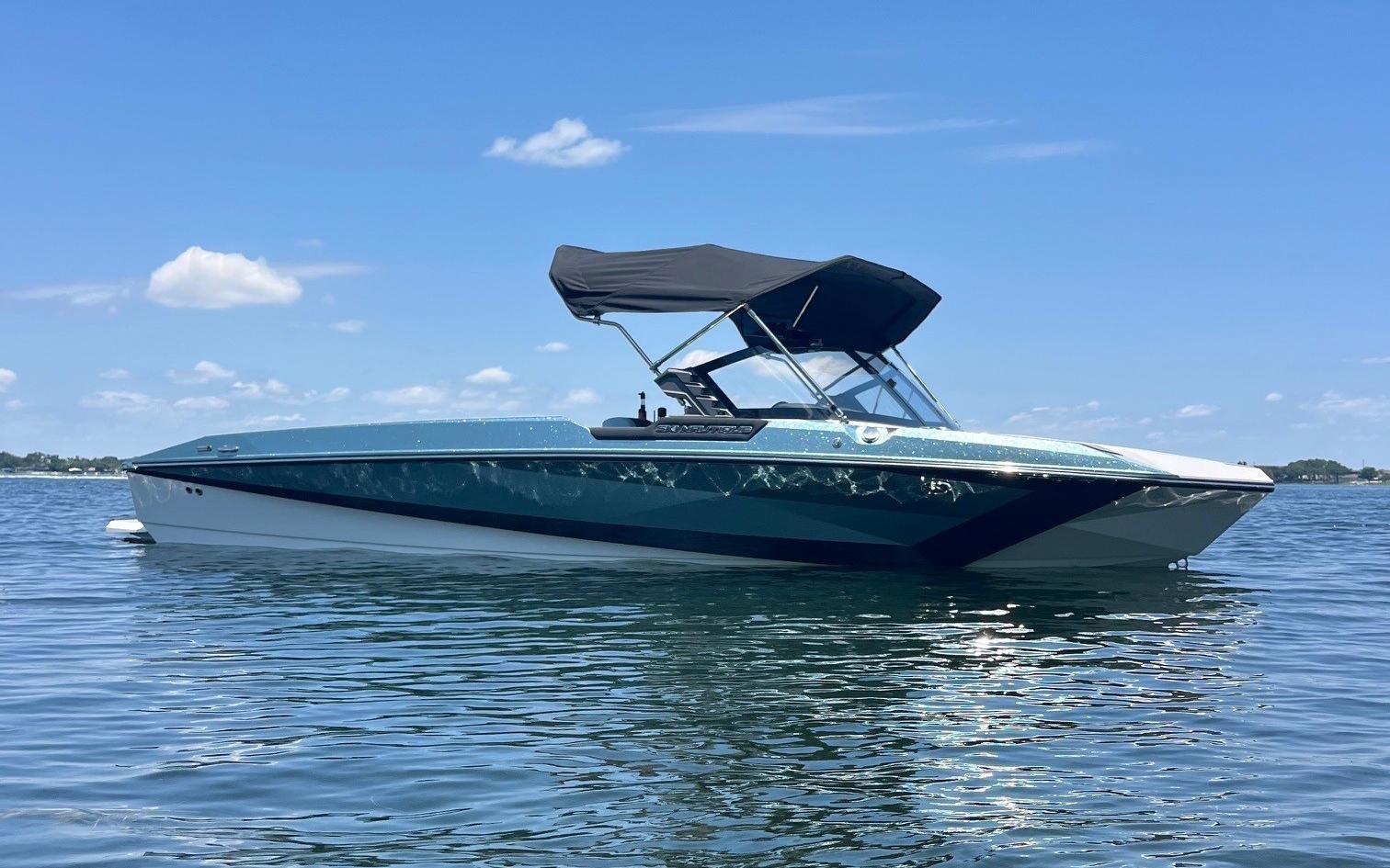 Nautique Ski Nautique 2025 Nautique Ski boat on calm water under a clear blue sky.