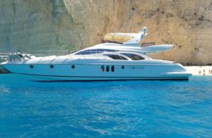 Azimut 62 2004 Azimut 62 yacht in clear blue water near rocky cliffs.