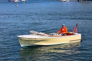 Dyer Glamour Girl A 2023 Dyer Glamour Girl boat on water, with a person steering and an American flag.