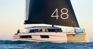 Nautitech 48 open 2024 Nautitech 48 Open catamaran sailing on the ocean with black sails.