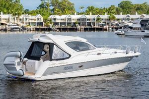 Mustang 3800ST 2006 Mustang 3800ST boat cruising on a scenic waterfront with modern homes in the background.