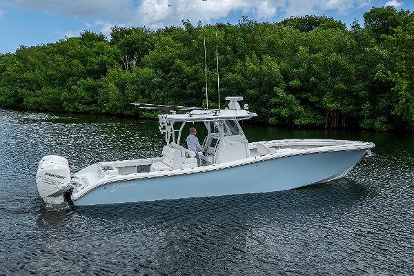 Yellowfin 36 2021 Yellowfin 36 boat cruising on a calm river with lush green trees.