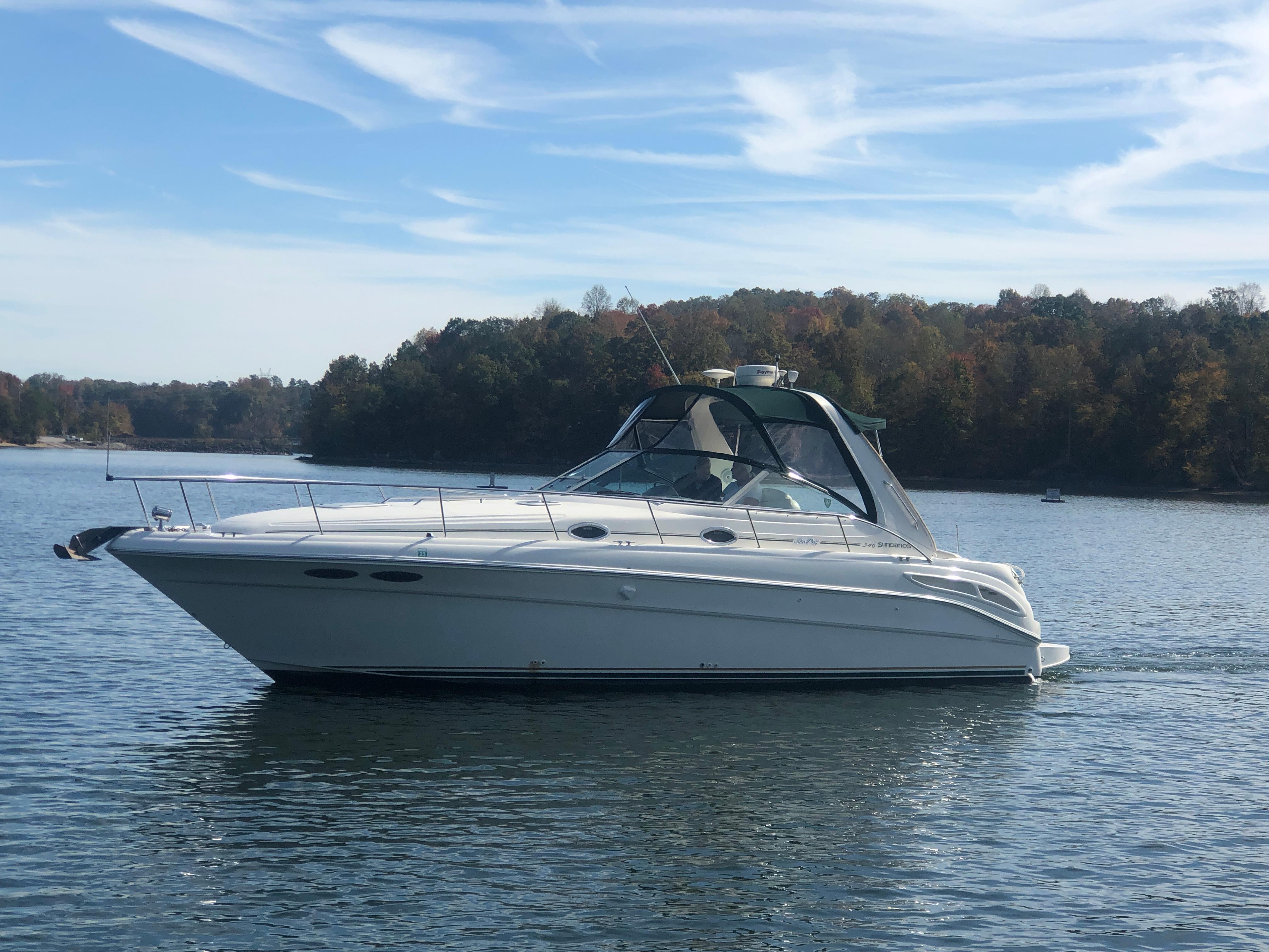 Sea Ray 340 Sundancer 2000 Sea Ray 340 Sundancer yacht on a calm lake with forested shoreline.