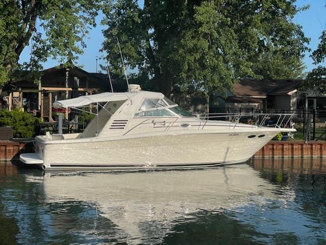 Sea Ray 330 Express 1997 Sea Ray 330 Express boat docked by a tree-lined waterfront.