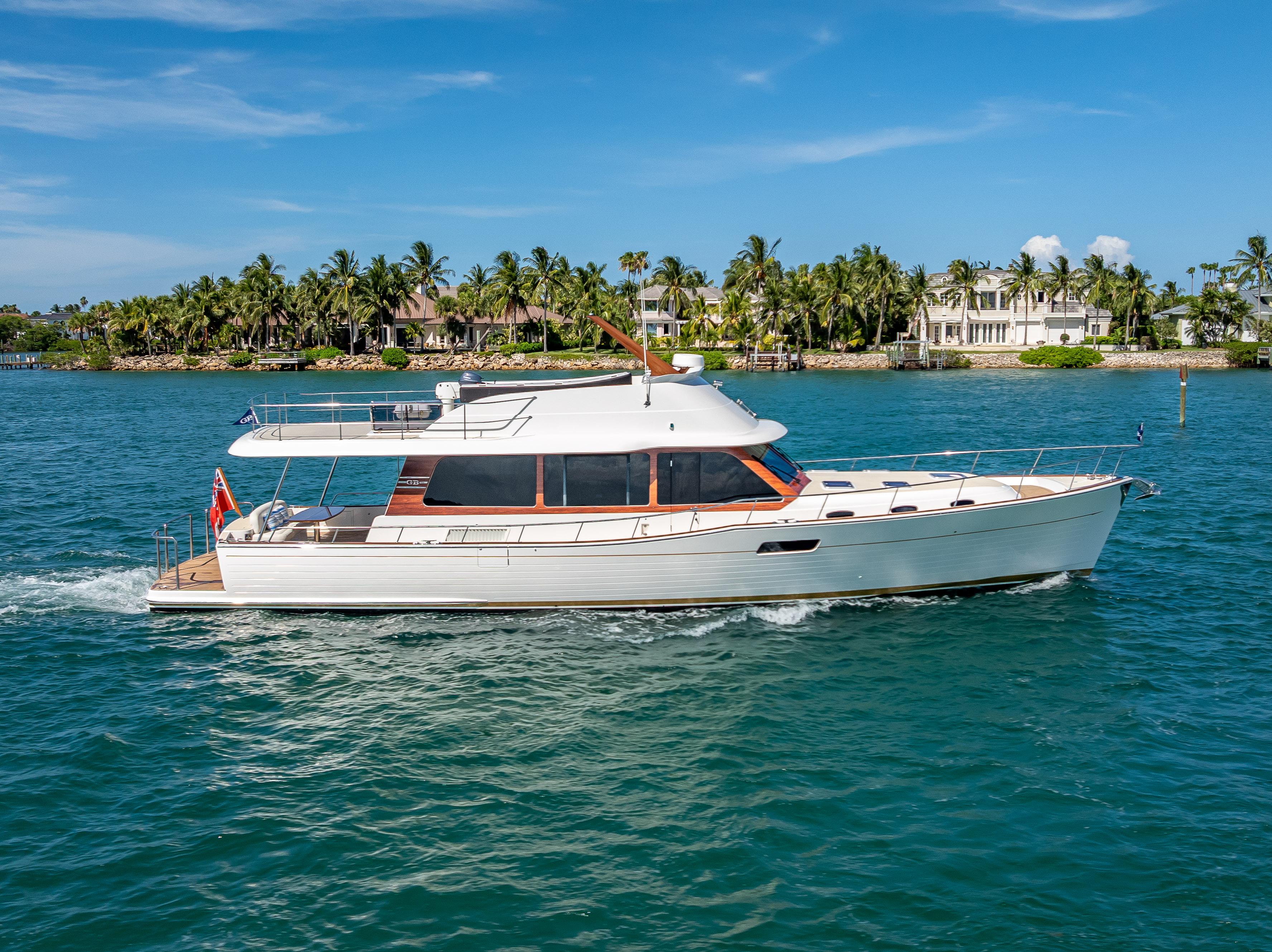 Grand Banks GB60 2018 Grand Banks GB60 yacht cruising on blue water near a tropical shoreline.