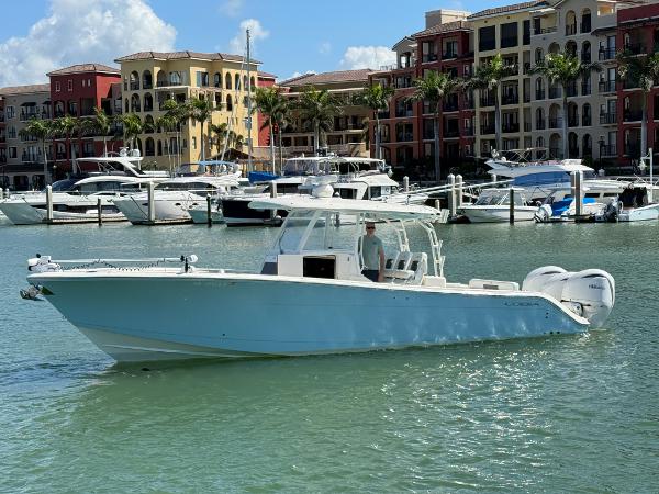 Cobia 350 Center Console 2023 Cobia 350 Center Console boat docked in a marina with luxury buildings.